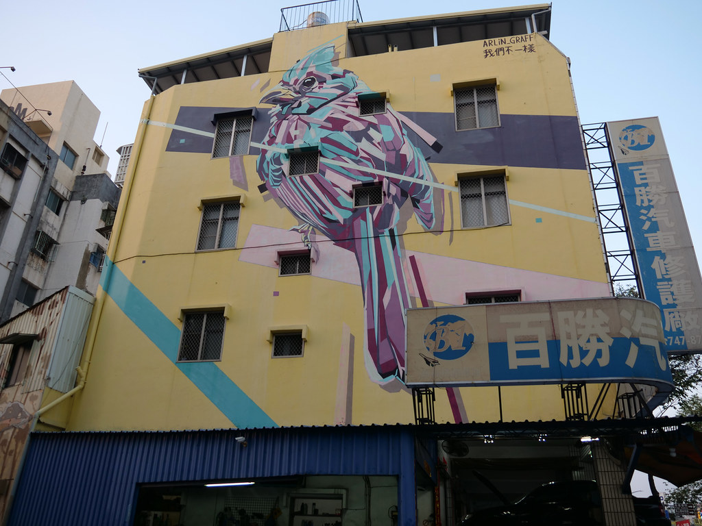黃色建築外牆上的大型幾何鳥類壁畫